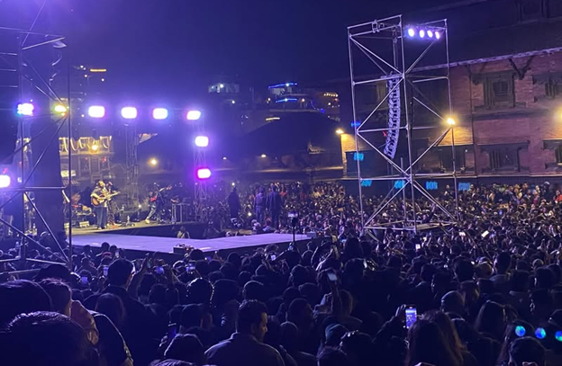 Large concert stage with dramatic dynamic lighting and atmospheric haze