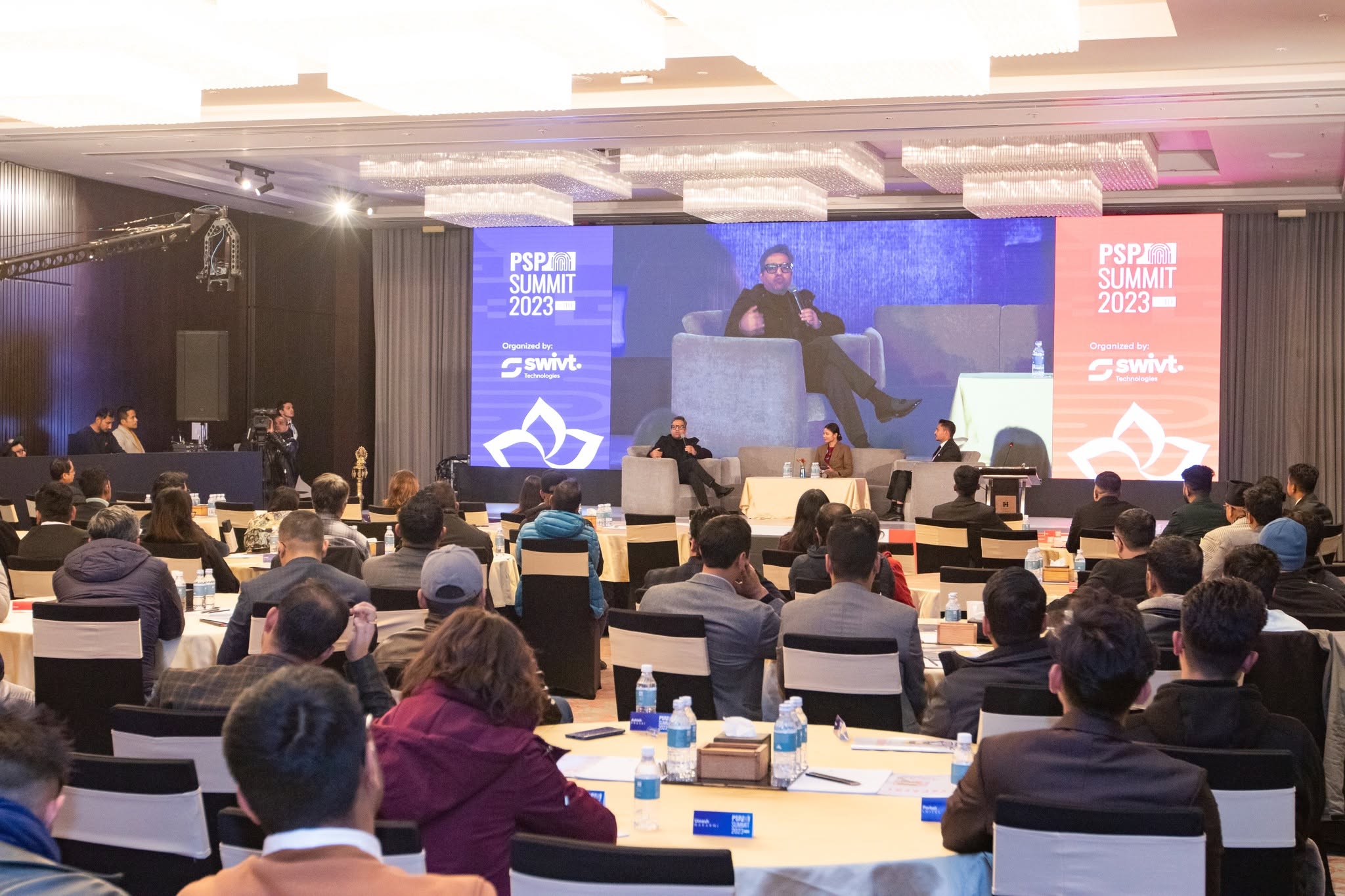 High-end corporate conference stage with large LED backdrop and executive audience